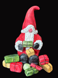 Small gnome figurine with colorful presents on a dark surface