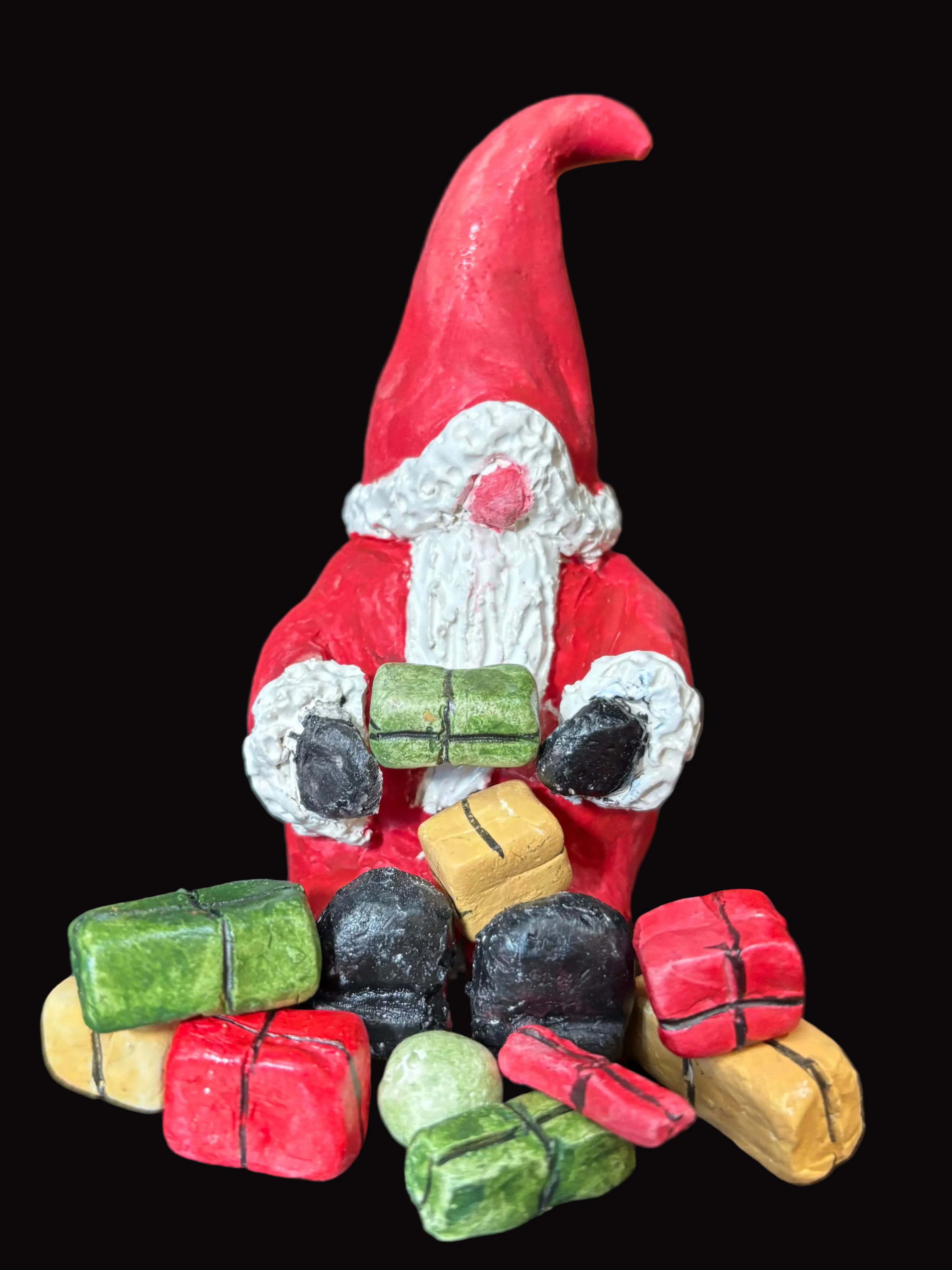 Small gnome figurine with colorful presents on a dark surface